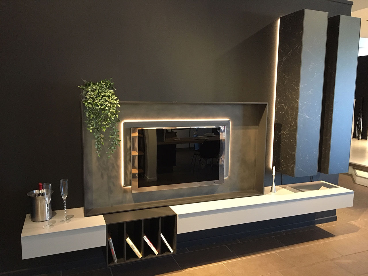 Parete attrezzata Caccaro con mobile TV in laccato scuro, boiserie in gres effetto marmo e illuminazione a LED integrata